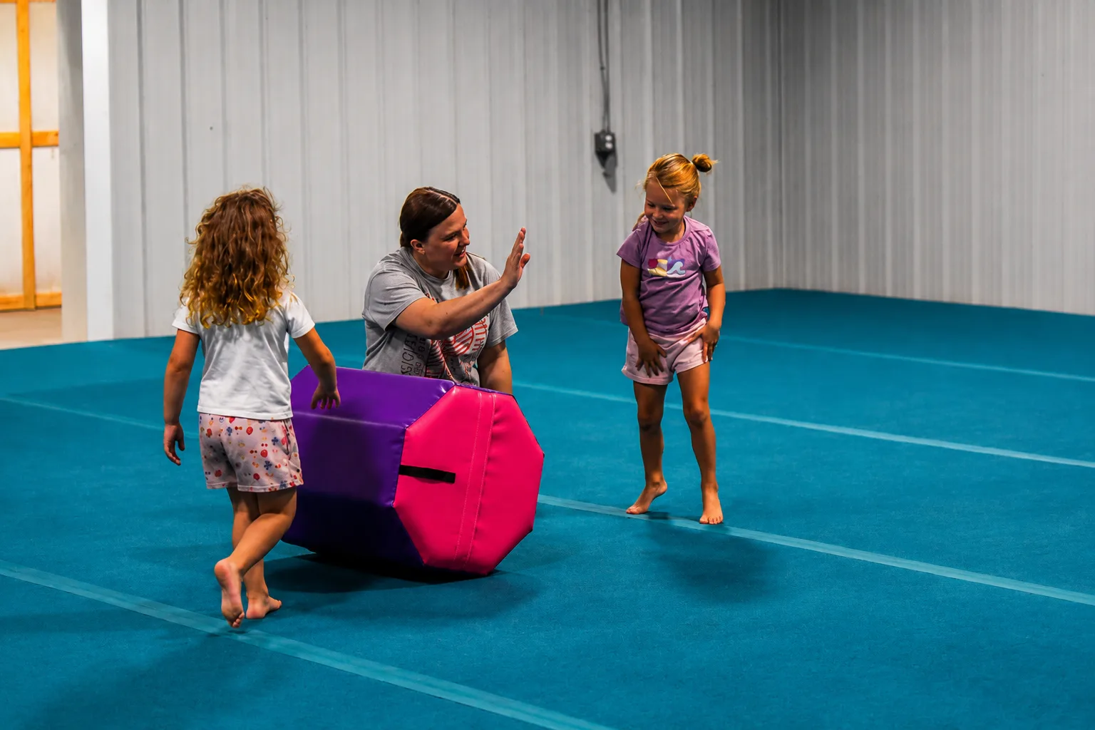 Coach encouraging young athletes during beginner tumbling practice at Bloom Cheer and Tumbling in Hot Springs