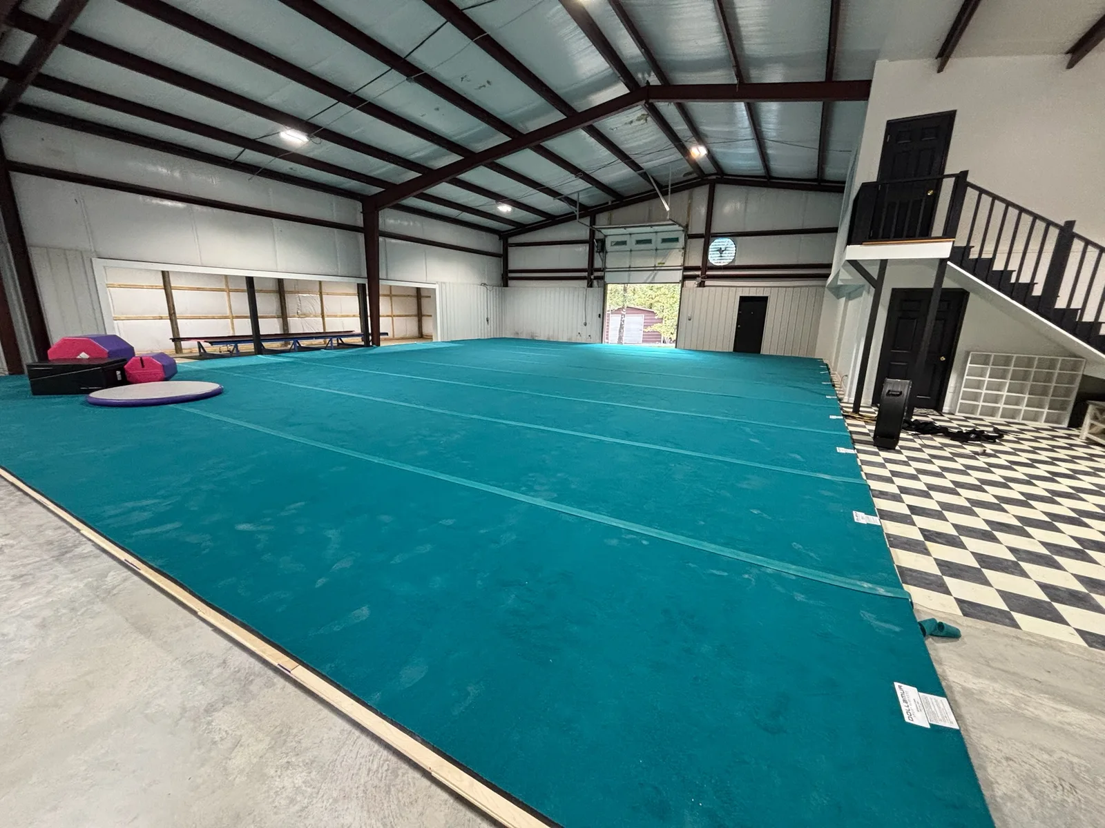 Teal competition floor at Bloom Cheer & Tumbling in Hot Springs, Arkansas